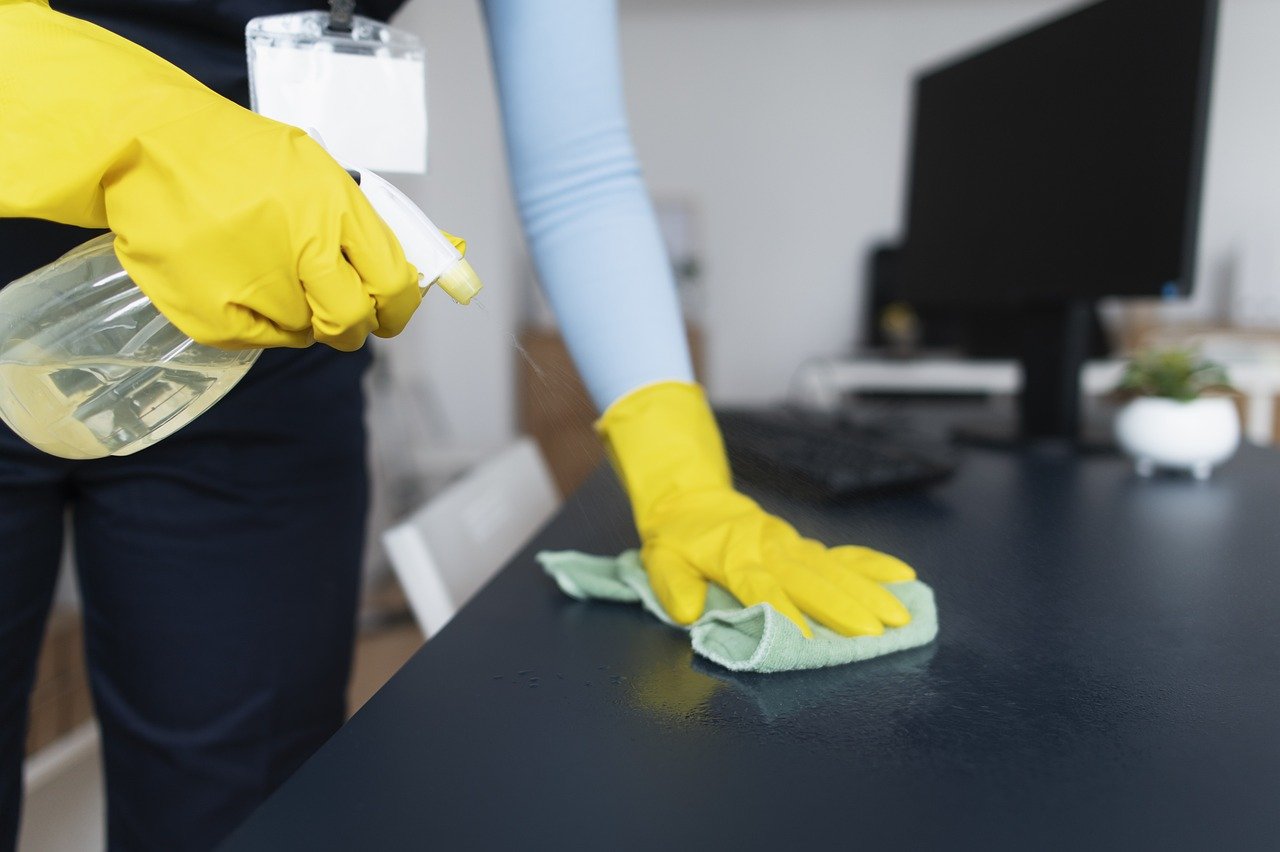 cleaning company disinfecting office desk